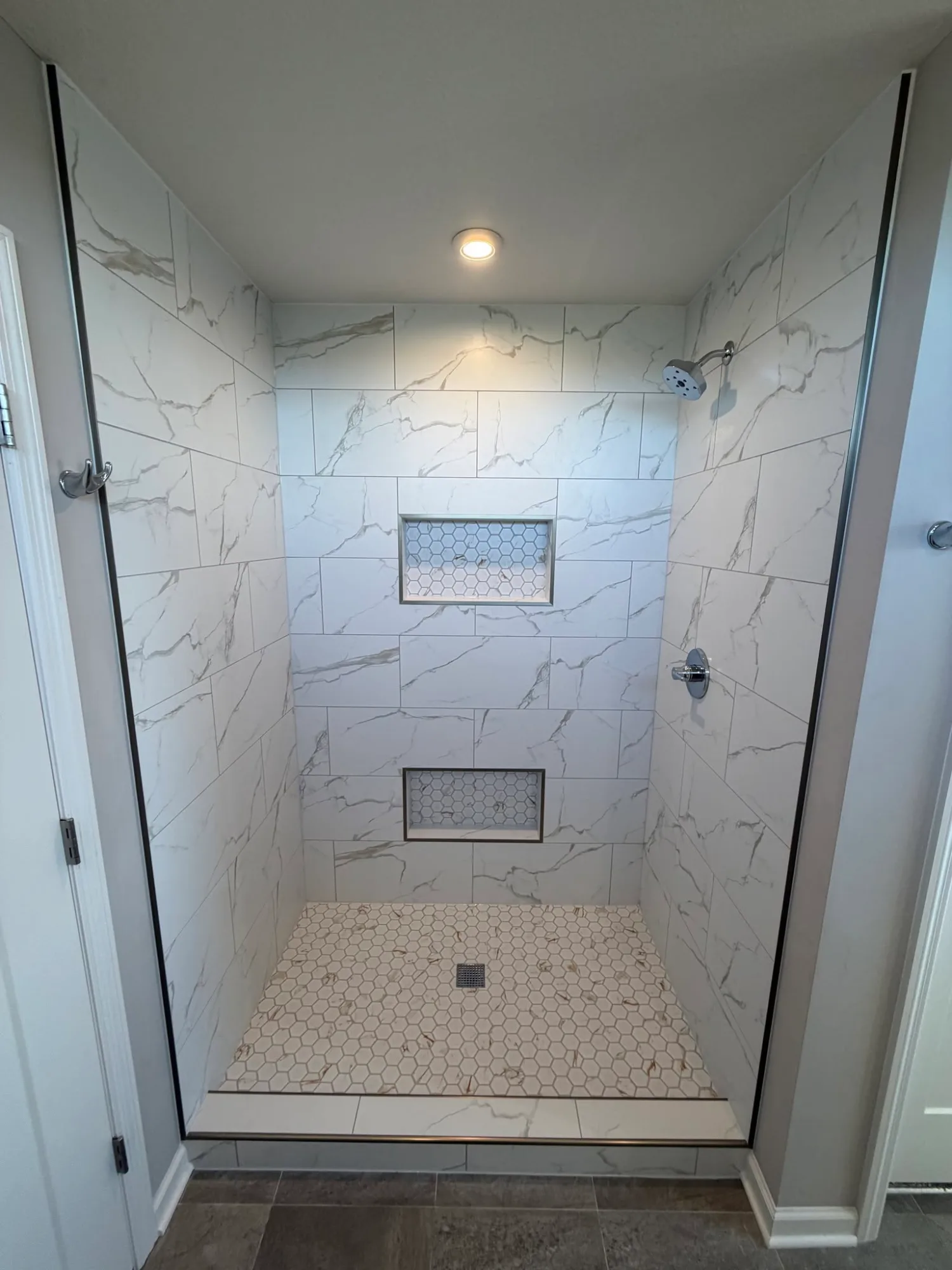 Custom porcelain tile walk-in shower built on a presloped mud bed in a Minnetrista, MN home